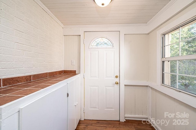 doorway with ornamental molding and dark hardwood / wood-style flooring