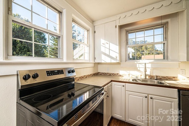 kitchen with sink, white cabinets, black dishwasher, and stainless steel range with electric stovetop