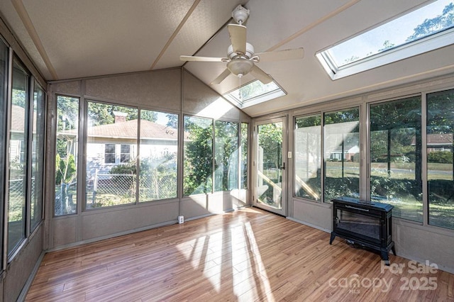 unfurnished sunroom with ceiling fan and vaulted ceiling with skylight