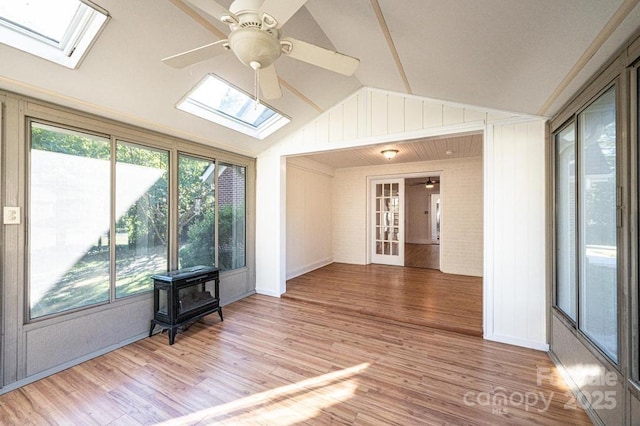 unfurnished sunroom with ceiling fan and lofted ceiling with skylight