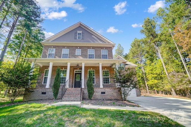 craftsman-style house featuring covered porch, a front lawn, and a garage