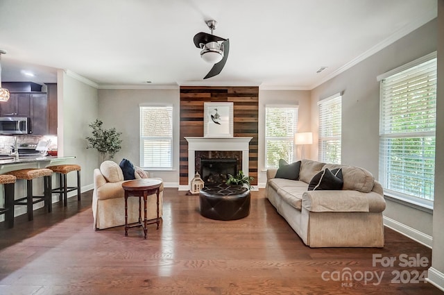 living room with dark hardwood / wood-style flooring, crown molding, and plenty of natural light