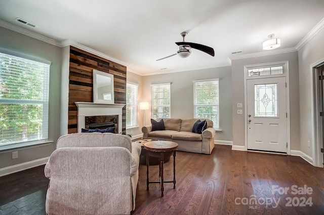 living room with dark wood-type flooring, ornamental molding, and a wealth of natural light