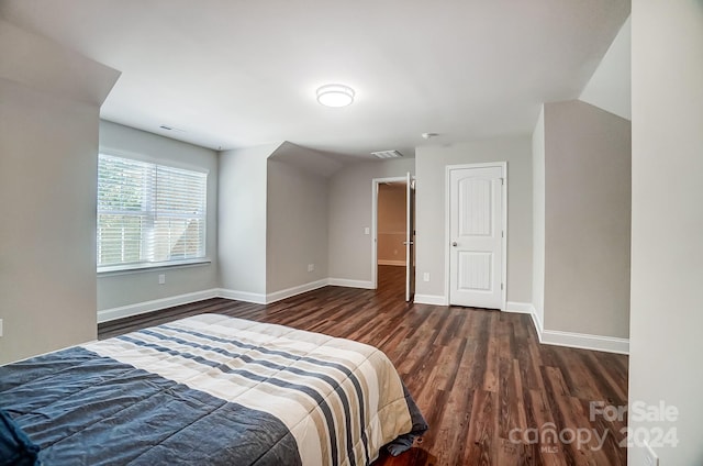 bedroom with dark wood-type flooring and lofted ceiling