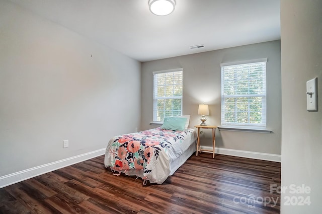 bedroom with dark wood-type flooring