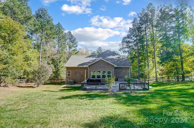 back of property with a yard, a deck, and central air condition unit