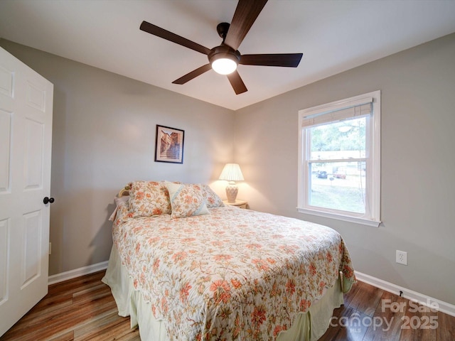 bedroom with ceiling fan, wood finished floors, and baseboards