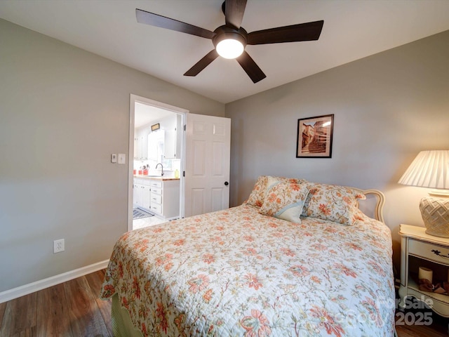 bedroom with a ceiling fan, dark wood-style flooring, a sink, and baseboards