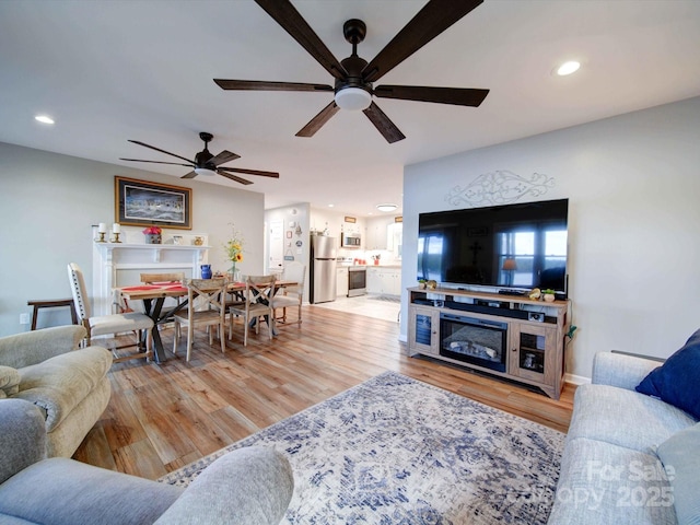 living room with light wood-type flooring and recessed lighting