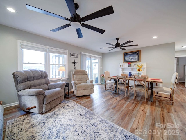 living room with light wood-type flooring, baseboards, and recessed lighting