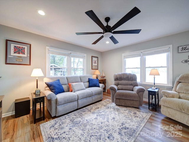 living area featuring a wealth of natural light, baseboards, recessed lighting, and wood finished floors