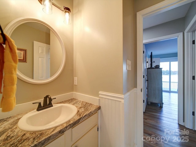 bathroom featuring a wainscoted wall, wood finished floors, and vanity