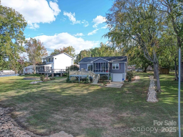 back of property with a sunroom, stairway, a lawn, and a wooden deck