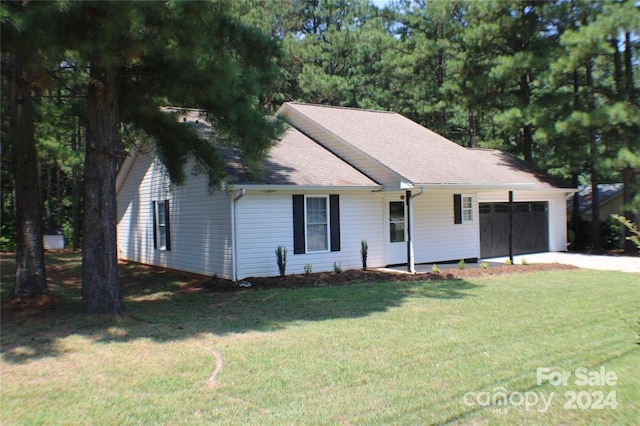 view of front of house with a garage and a front lawn