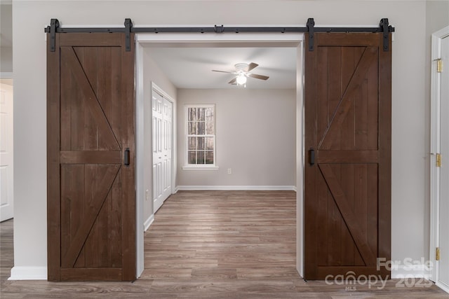 interior space with a barn door and light hardwood / wood-style flooring