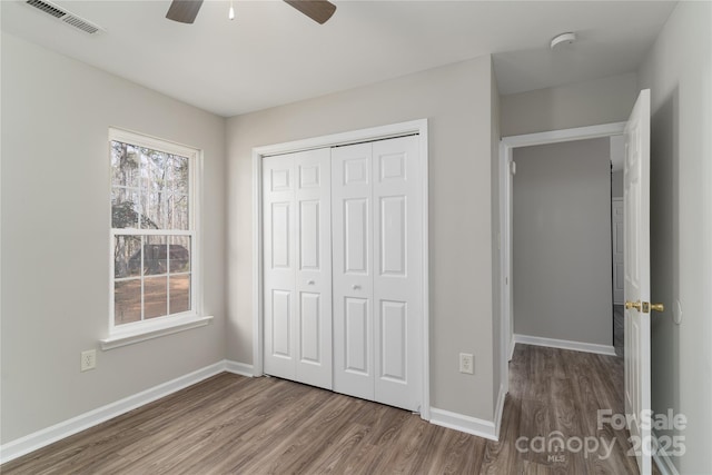 unfurnished bedroom with a closet, hardwood / wood-style flooring, and ceiling fan