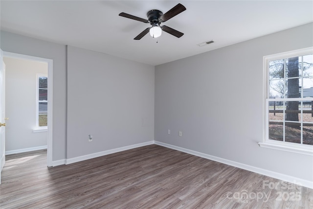 empty room with dark hardwood / wood-style floors and ceiling fan