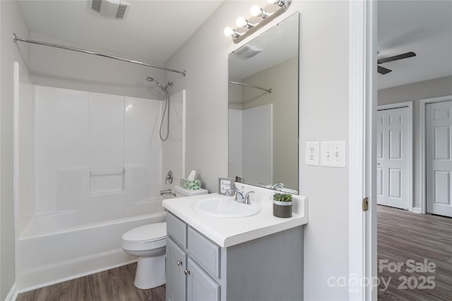 full bathroom with toilet, wood-type flooring, bathing tub / shower combination, and vanity