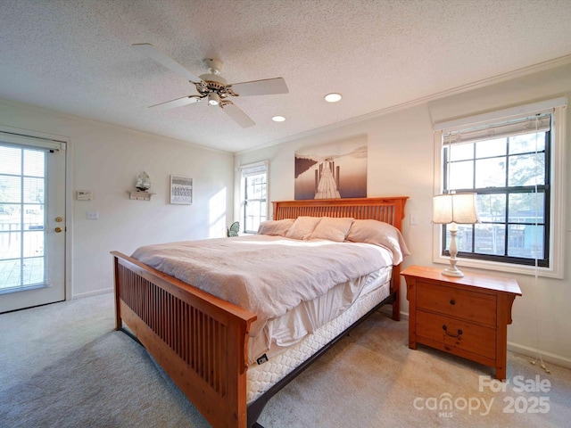 bedroom with light carpet, ceiling fan, baseboards, and a textured ceiling