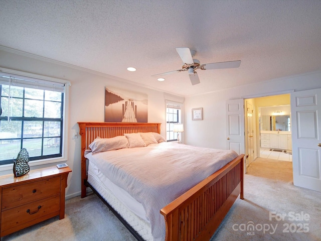 bedroom featuring a textured ceiling, ceiling fan, ornamental molding, and light colored carpet