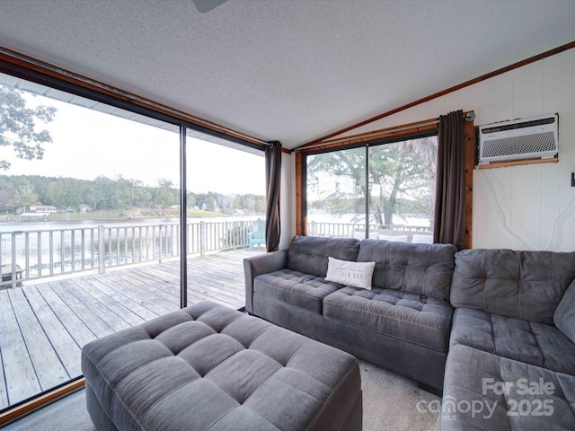 living area with a water view, a healthy amount of sunlight, a wall mounted AC, and lofted ceiling