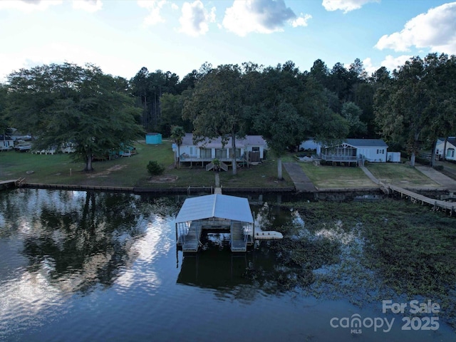 view of dock featuring a lawn, a water view, and boat lift