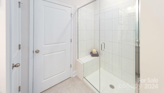 bathroom featuring tile patterned flooring and an enclosed shower