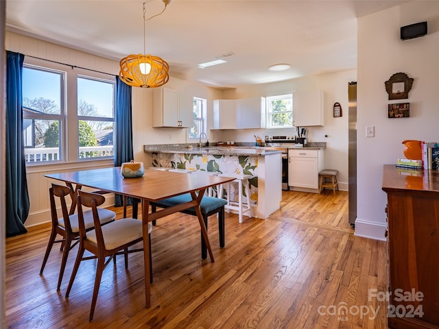 dining room with sink and light wood-type flooring