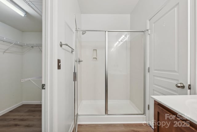 bathroom featuring hardwood / wood-style flooring, vanity, and a shower with door