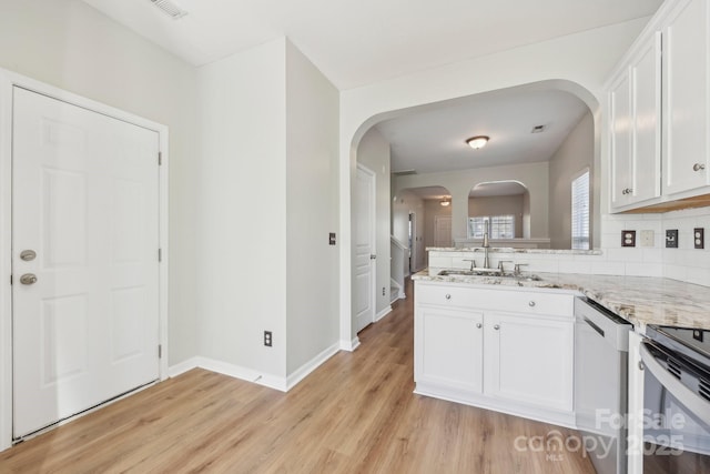 kitchen with light stone countertops, white cabinetry, sink, and stainless steel dishwasher