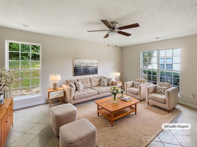 tiled living room featuring ceiling fan, a textured ceiling, and plenty of natural light