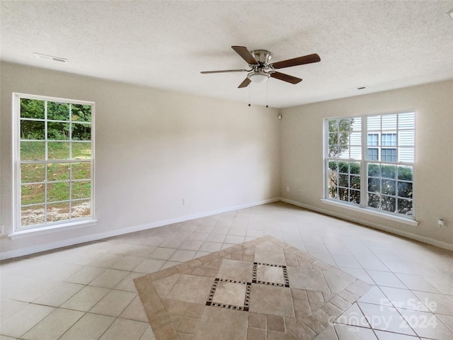 tiled empty room with a textured ceiling and ceiling fan