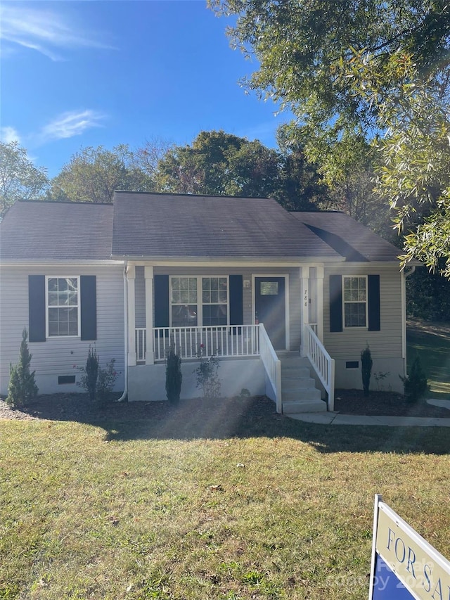 single story home featuring covered porch and a front lawn