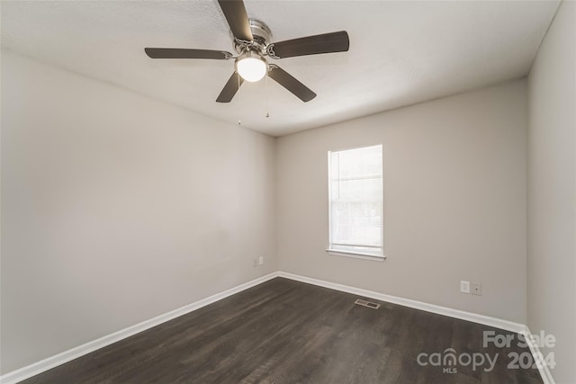 empty room with ceiling fan and dark hardwood / wood-style flooring