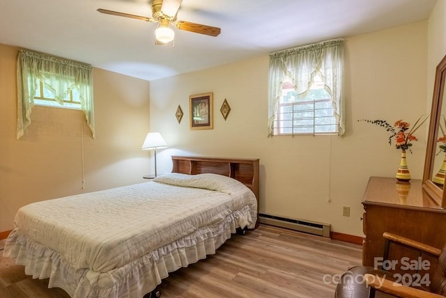 bedroom featuring a baseboard radiator, light hardwood / wood-style floors, and ceiling fan