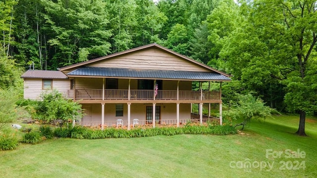 back of house featuring a yard and a balcony