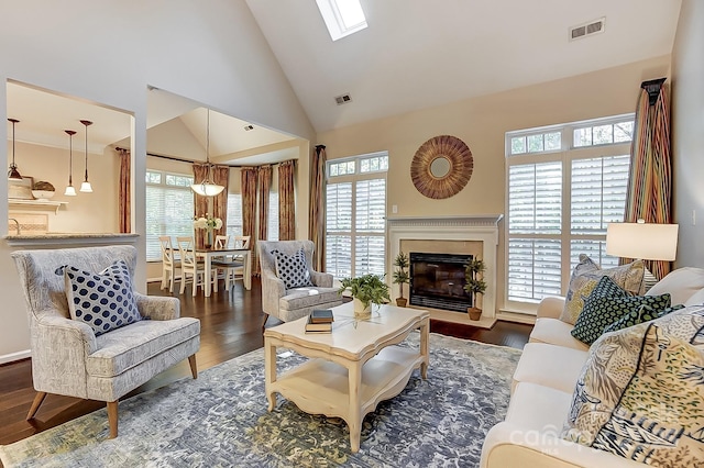 living room featuring dark hardwood / wood-style flooring, high vaulted ceiling, and a healthy amount of sunlight