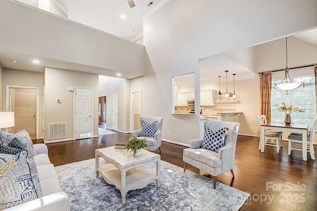 living room with dark hardwood / wood-style floors and a towering ceiling