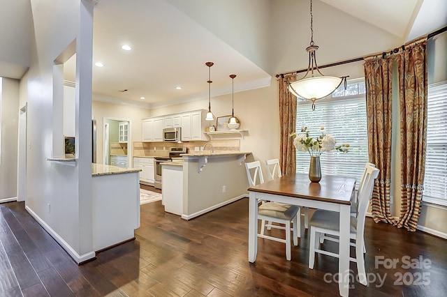 dining area featuring dark wood-type flooring and vaulted ceiling