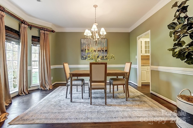 dining area with a healthy amount of sunlight, dark hardwood / wood-style flooring, crown molding, and an inviting chandelier