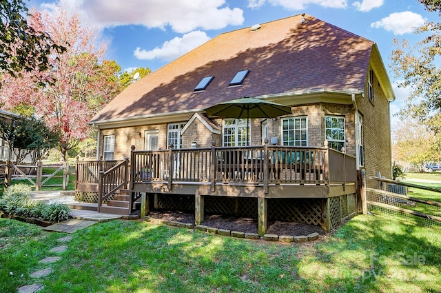 rear view of property with a yard and a deck