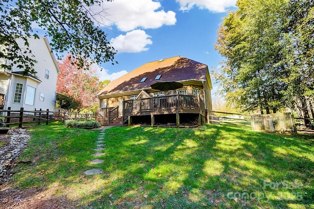 back of property featuring a deck and a lawn