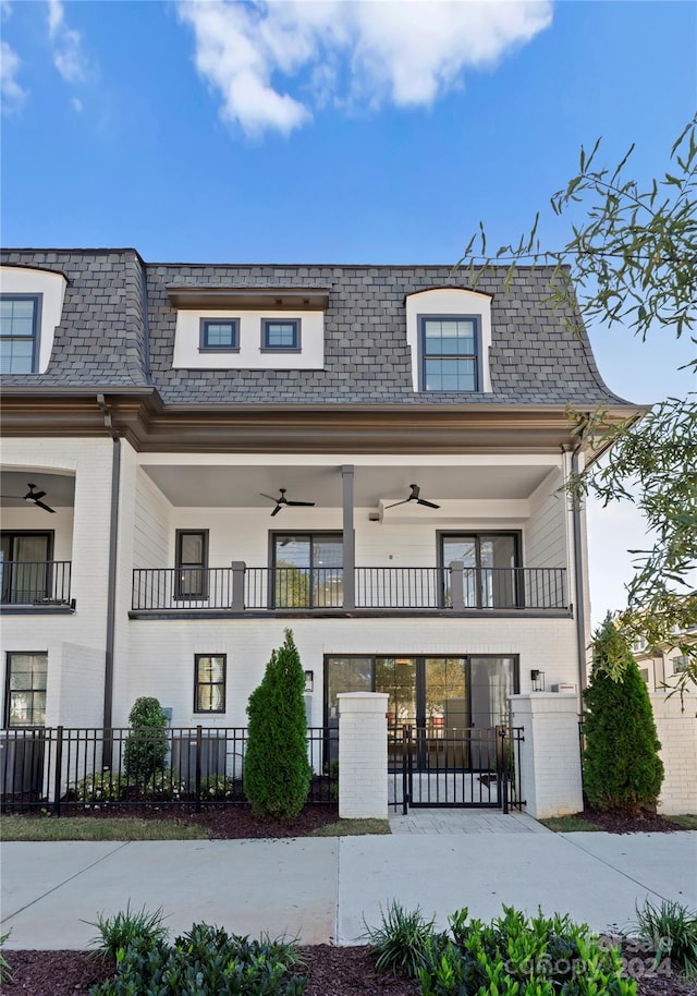 view of front of property featuring ceiling fan and a balcony