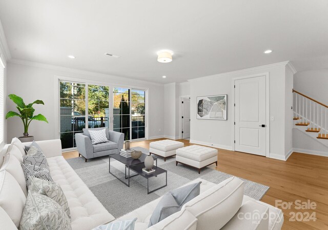 living room with crown molding and light wood-type flooring