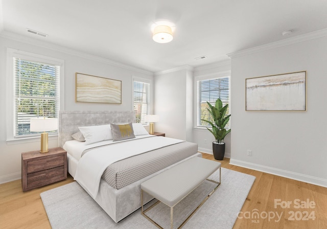 bedroom featuring ornamental molding and light wood-type flooring