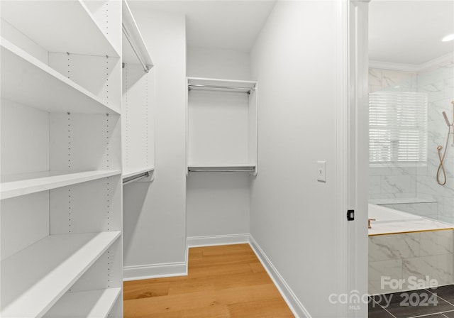 walk in closet with hardwood / wood-style floors