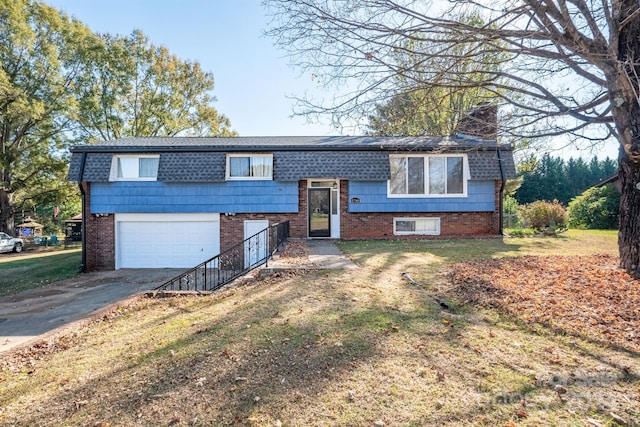 split foyer home featuring a front lawn and a garage