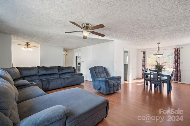 living room featuring hardwood / wood-style floors, a textured ceiling, and ceiling fan