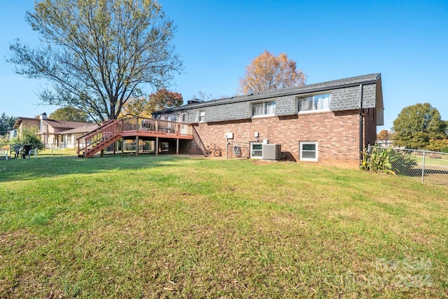 rear view of house with a wooden deck, cooling unit, and a yard