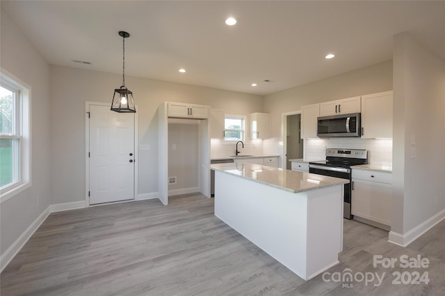 kitchen featuring white cabinetry, a healthy amount of sunlight, light hardwood / wood-style flooring, and stainless steel appliances